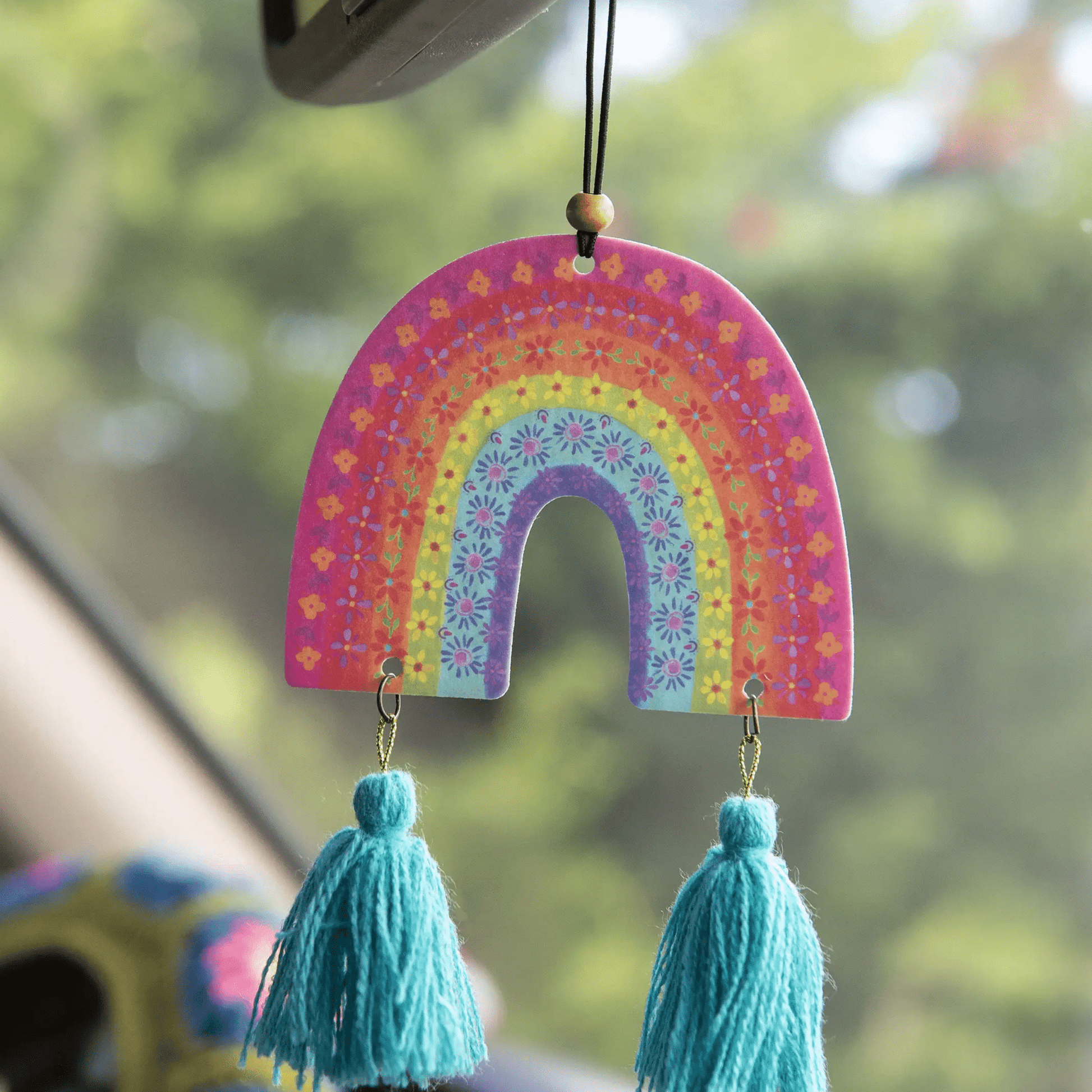 Brightly colored rainbow air freshener featuring intricate patterns, designed for freshening cars or homes."